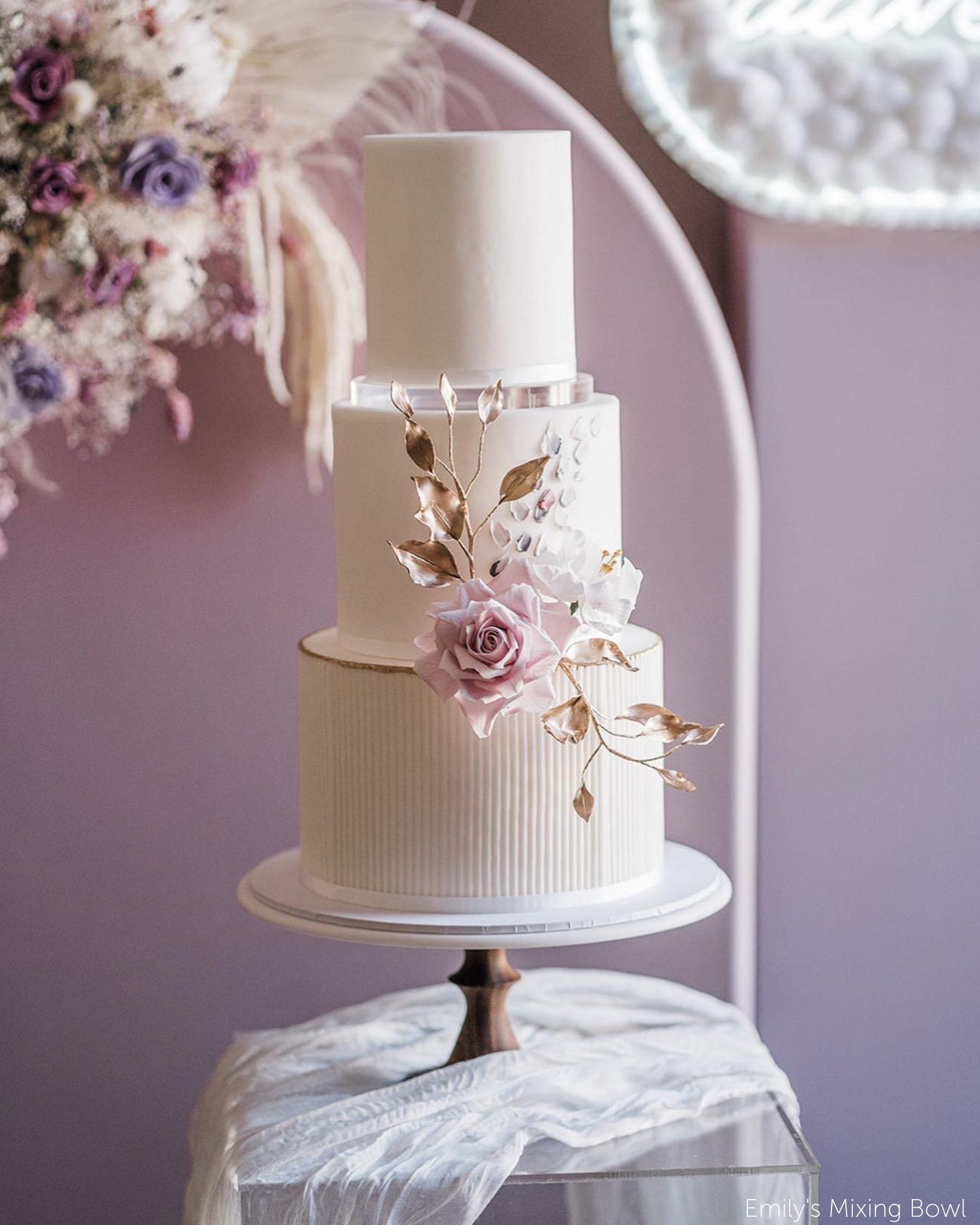 Plain white wedding cake with subtle floral decorations on the front, the tiers are separated using 15mm Acrylic Cake Separators - Prop Options