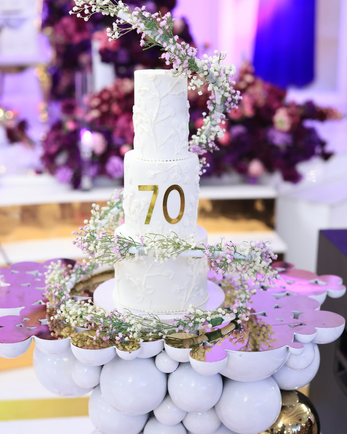 Cake Spiral - Metal Wrap, white plastic-coated metal spiral wound around a four tier white wedding cake with floral detail