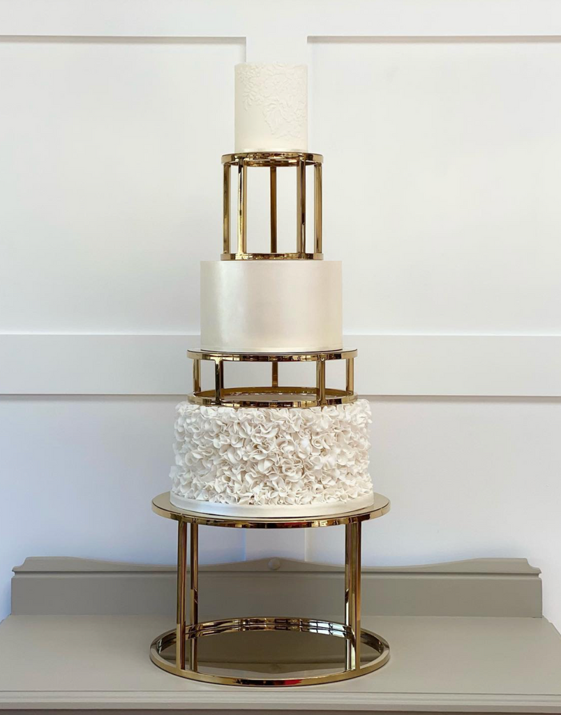 Gold Round Metallic Plinth holding up a white multitiered cake with gold separators between each layer - Prop Options