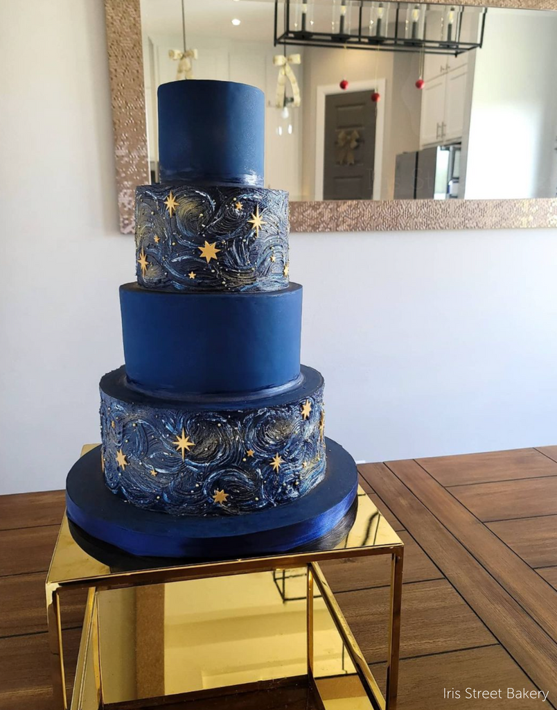 Gold Square Metallic Plinth holding up a dark blue space themed cake with gold star imagery on alternating tiers - Prop Options