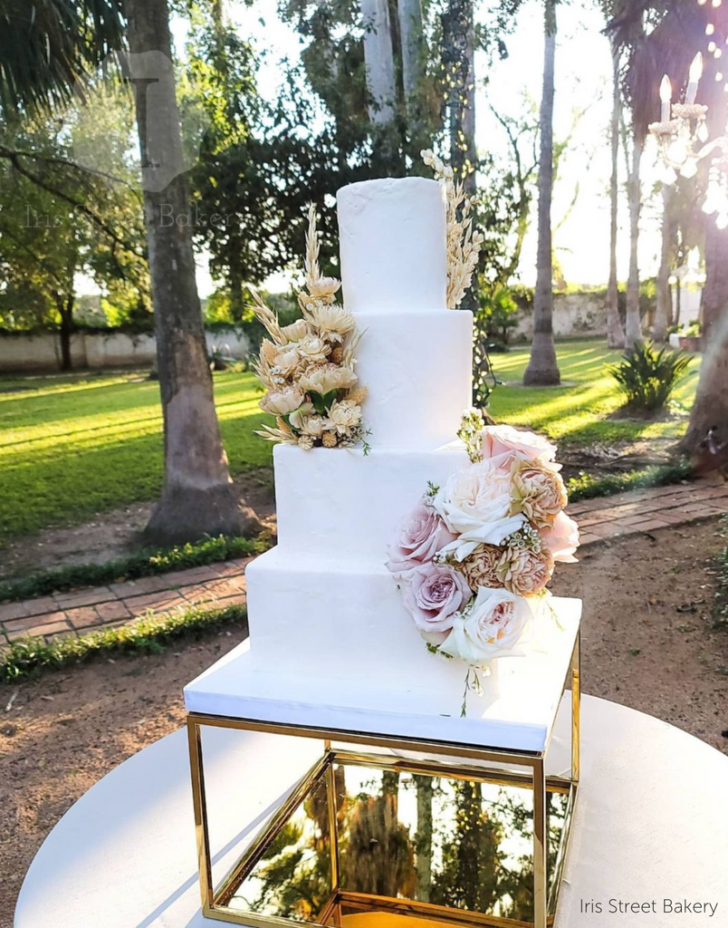 Gold Square Metallic Plinth holding up a white multilayered cake with pastel coloured flowers - Prop Options