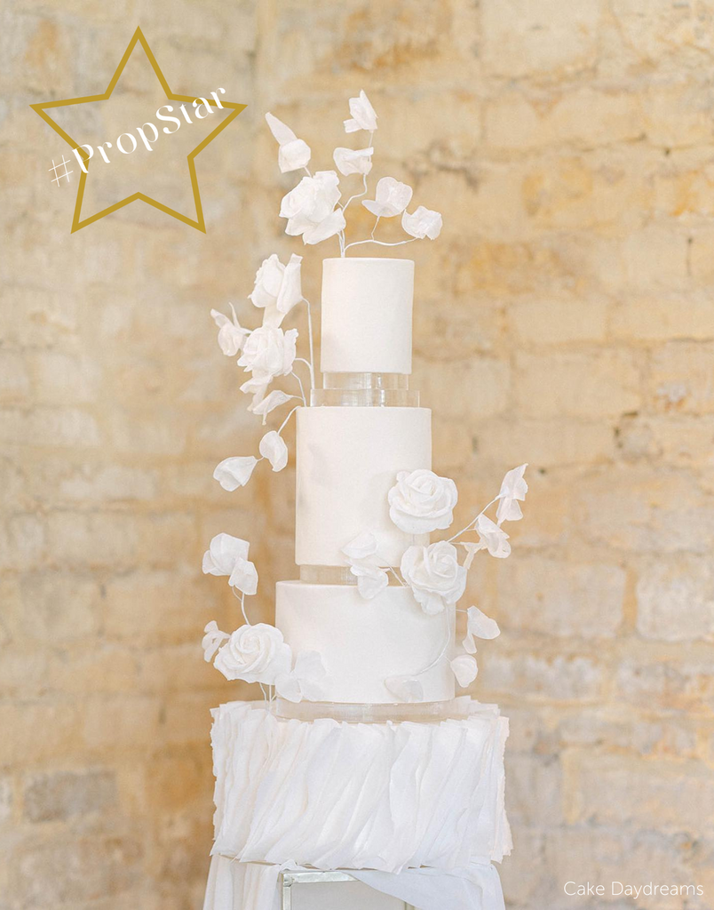 PropStar winning submission - white multitiered cake covered in white flowers, each layer is separated with 15mm Acrylic Cake Separators - Prop Options