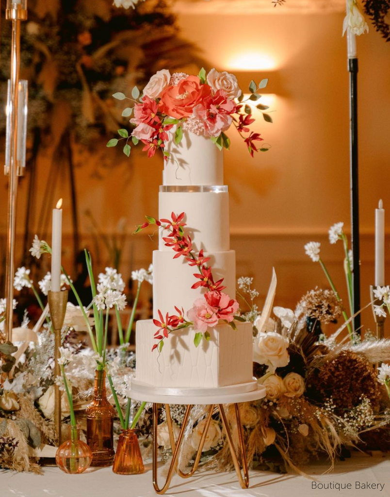 Tall multitiered white cake with red and pink florals, the layers are separated using 15mm Acrylic Cake Separators - Prop Options