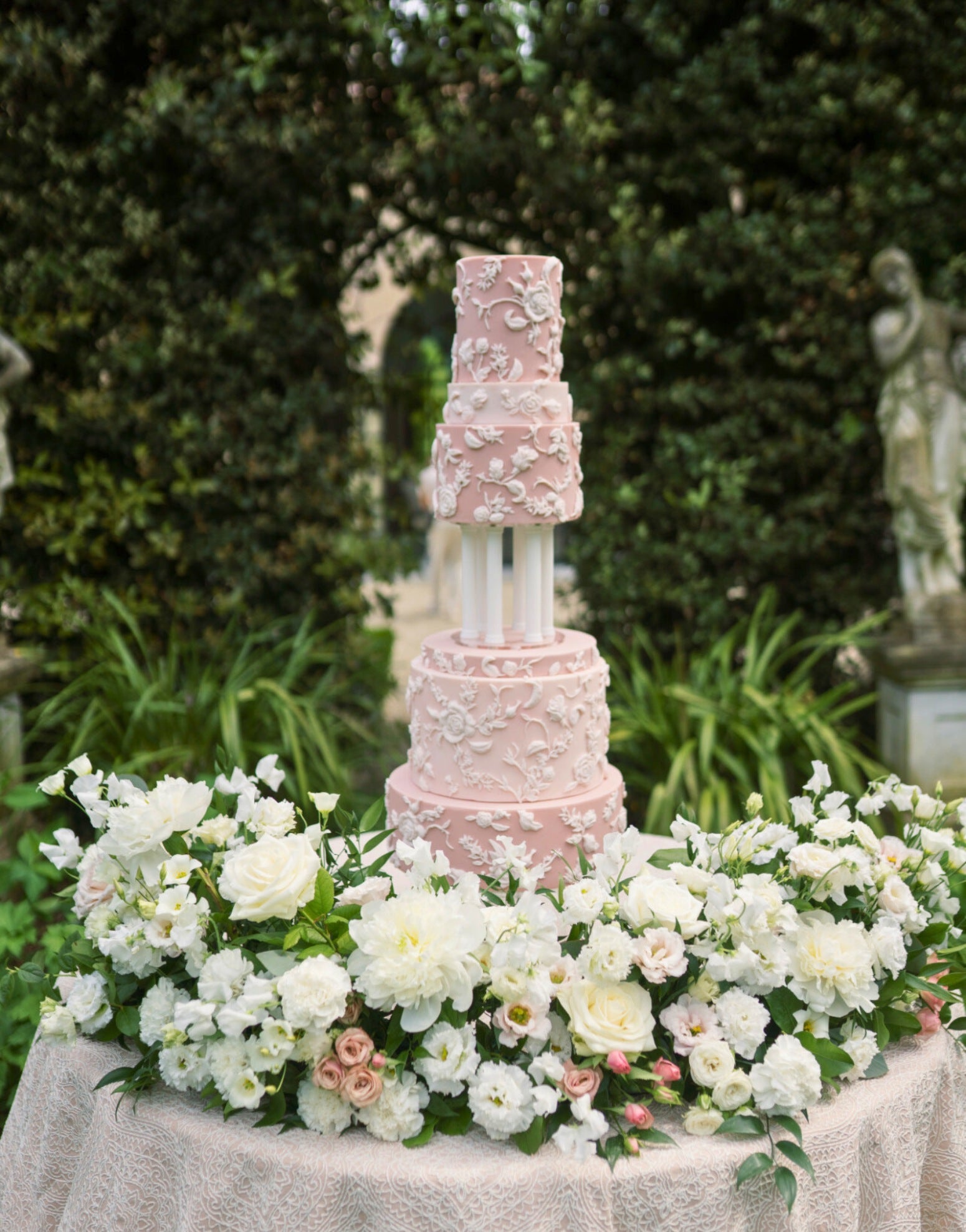 Tall wedding cake displayed using Prop Options column cake separator with soft pink floral decoration from Eruzlie cake 