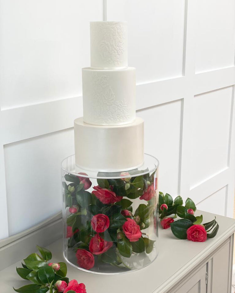 Round Acrylic Fillable Plinth filled with red roses holding up a plain round multitiered cake - Prop Options
