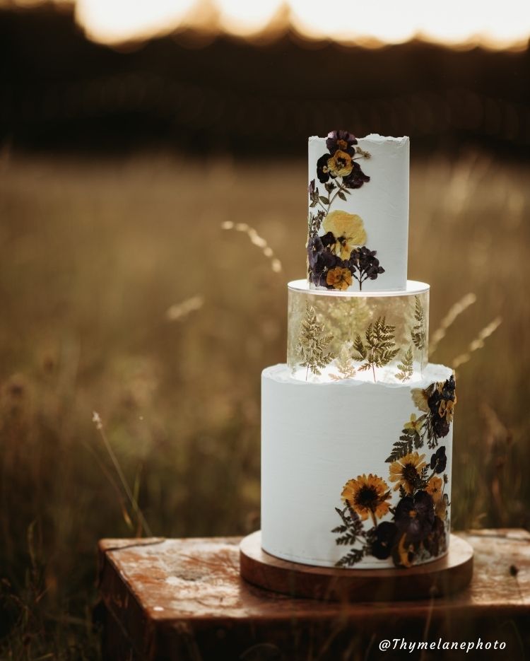 Stunning tiered cake using floral design and Prop Options clear tier expertly decorated with gold leaf design - floating cake  Edit alt text